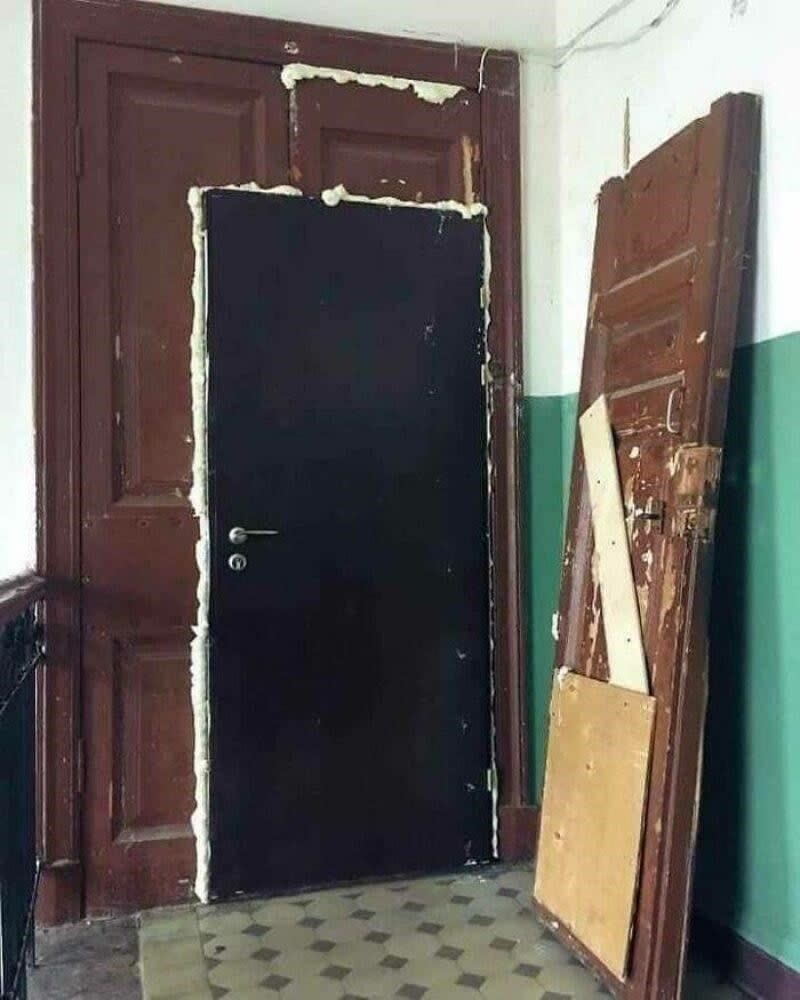 Door with insulation foam around it; another half of the door leaning against the wall nearby