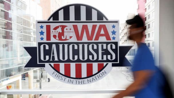 PHOTO: A pedestrian walks past a sign for the Iowa Caucuses on a downtown skywalk, in Des Moines, Iowa, Feb. 4, 2020.  (Charlie Neibergall/AP, FILE)