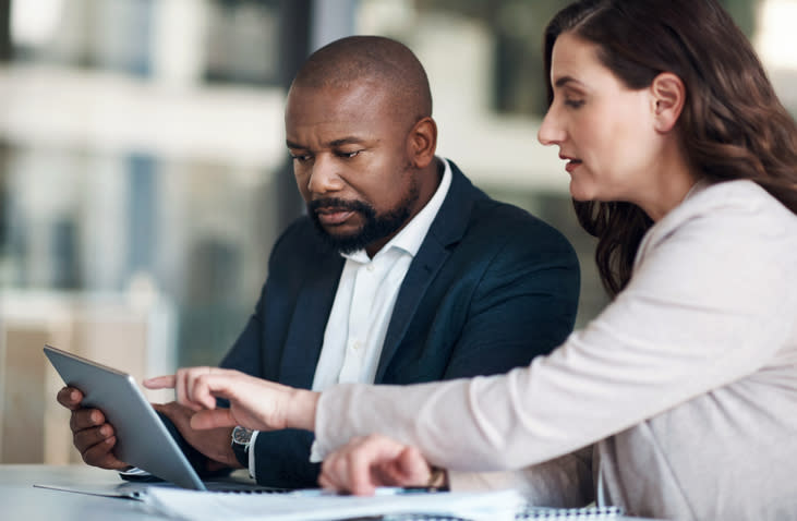 Two financial advisors reviewing creative marketing ideas for their firm.