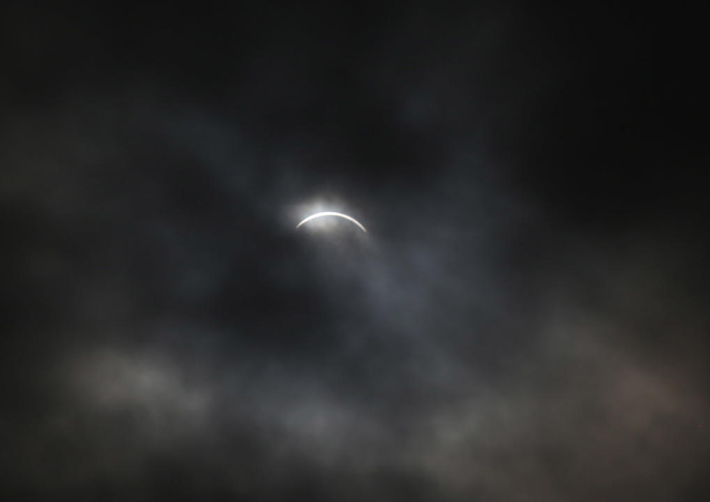 The partial phase of the total solar eclipse is seen through obscuring clouds in Gander, N.L., Monday, April 8, 2024. THE CANADIAN PRESS/Paul Daly