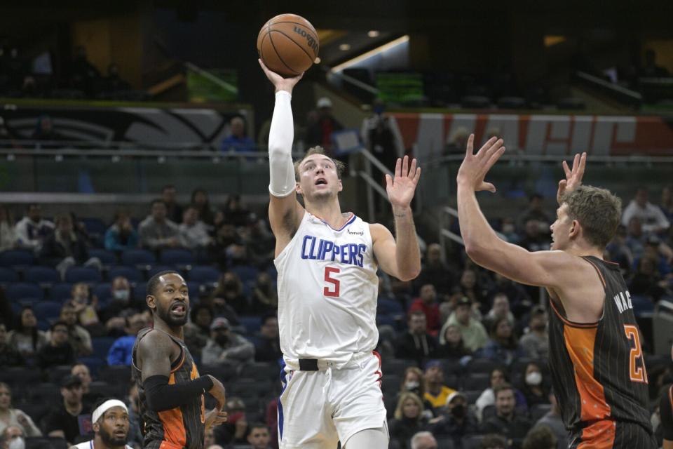 Clippers guard Luke Kennard puts up a shot between Orlando Magic guard Terrence Ross and center Moritz Wagner.