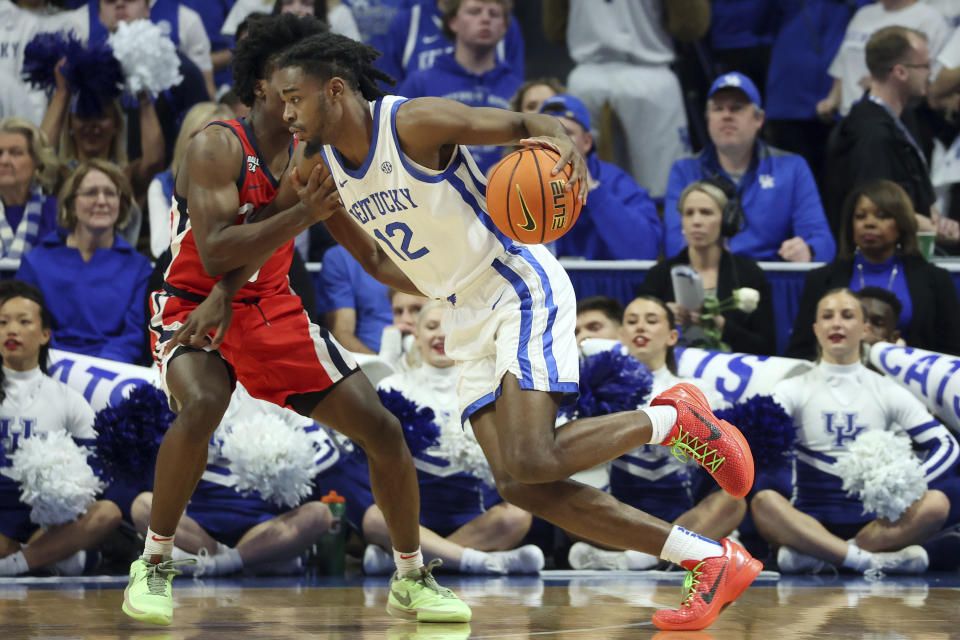 Kentucky's Antonio Reeves (12) drives while defended by Mississippi's Jaylen Murray (5) during the second half of an NCAA college basketball game Tuesday, Feb. 13, 2024, in Lexington, Ky. (AP Photo/James Crisp)