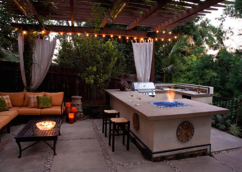 <p>Pour the wine and gather round-no walls needed. Add a fire pit to your outdoor kitchen for an entertaining space that's warm all winter.</p>