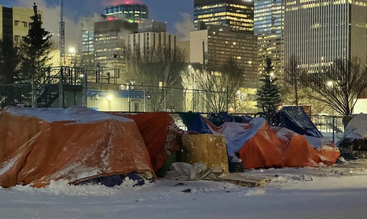 People gather outside the Bissell Centre in Edmonton early Thursday. (Wallis Snowdon/CBC - image credit)