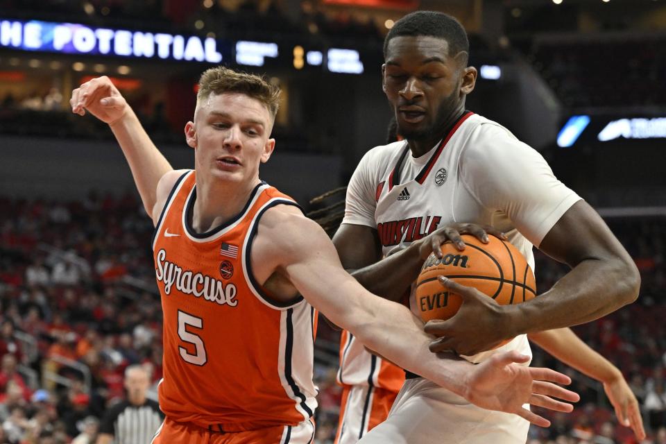 Louisville's Brandon Huntley-Hatfield battles Syracuse's Justin Taylor (5) for a rebound during the first half Saturday night. Huntley-Hatfield recorded a double-double in the home loss.