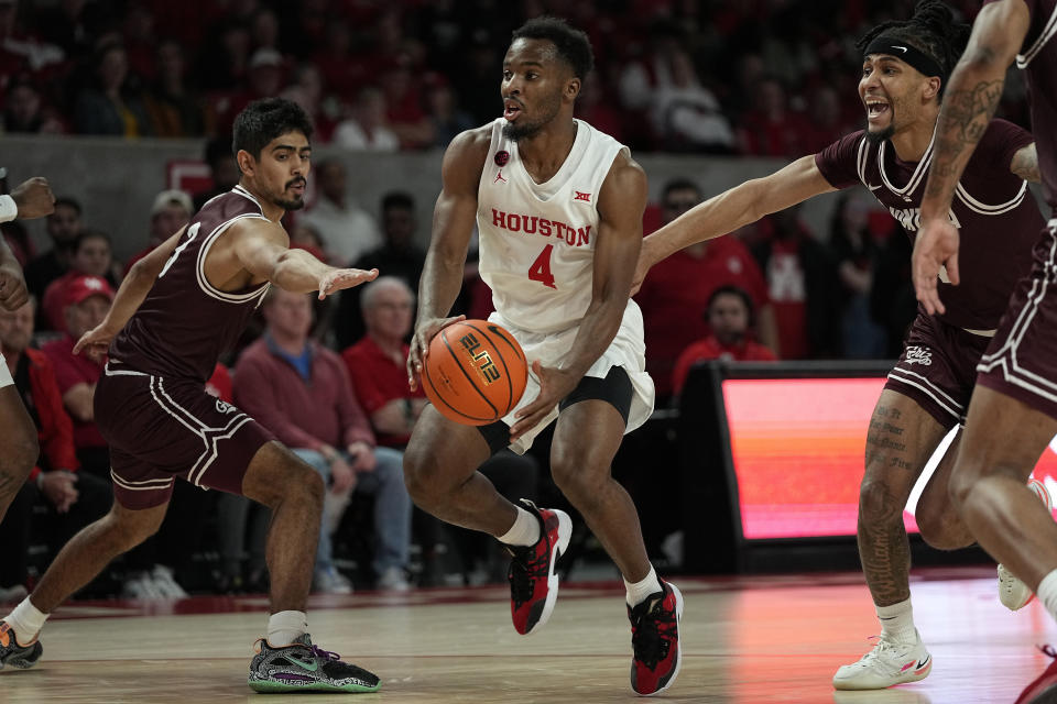 Houston guard LJ Cryer (4) drives between Montana guards Josh Vazquez and Giordan Williams during the first half of an NCAA college basketball game, Friday, Nov. 24, 2023, in Houston. (AP Photo/Kevin M. Cox)