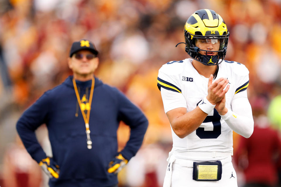 MINNEAPOLIS, MINNESOTA - OCTOBER 07: J.J. McCarthy #9 of the Michigan Wolverines warms up while head coach Jim Harbaugh looks on prior to the start of the game against the Minnesota Golden Gophers at Huntington Bank Stadium on October 07, 2023 in Minneapolis, Minnesota. The Wolverines defeated the Golden Gophers 52-10. (Photo by David Berding/Getty Images)