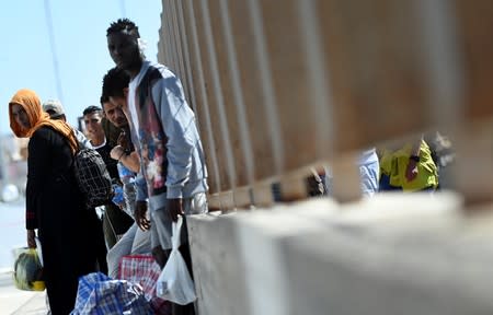 Migrants wait to embark a ferry to the mainland, in Lampedusa