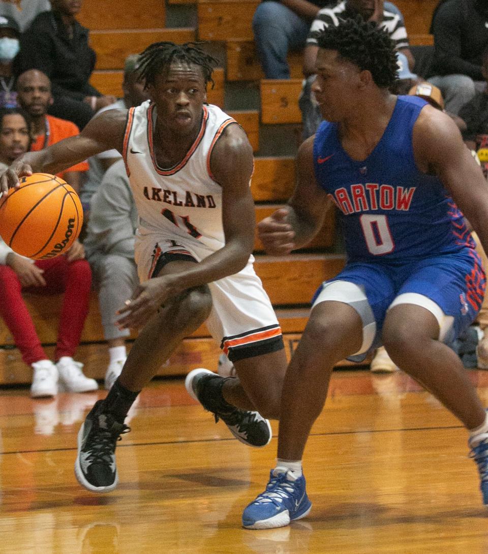 Lakeland High School's Derajah Hardy (11) drives under the basket as Bartow High School's Amarion Baker (0) tries to defend during the first half of their Class 6A, District 7 playoff game at Lakeland High School Friday night. Bartow won by a score of 62-56. February 11, 2022. MICHAEL WILSON | LEDGER CORRESPONDENT