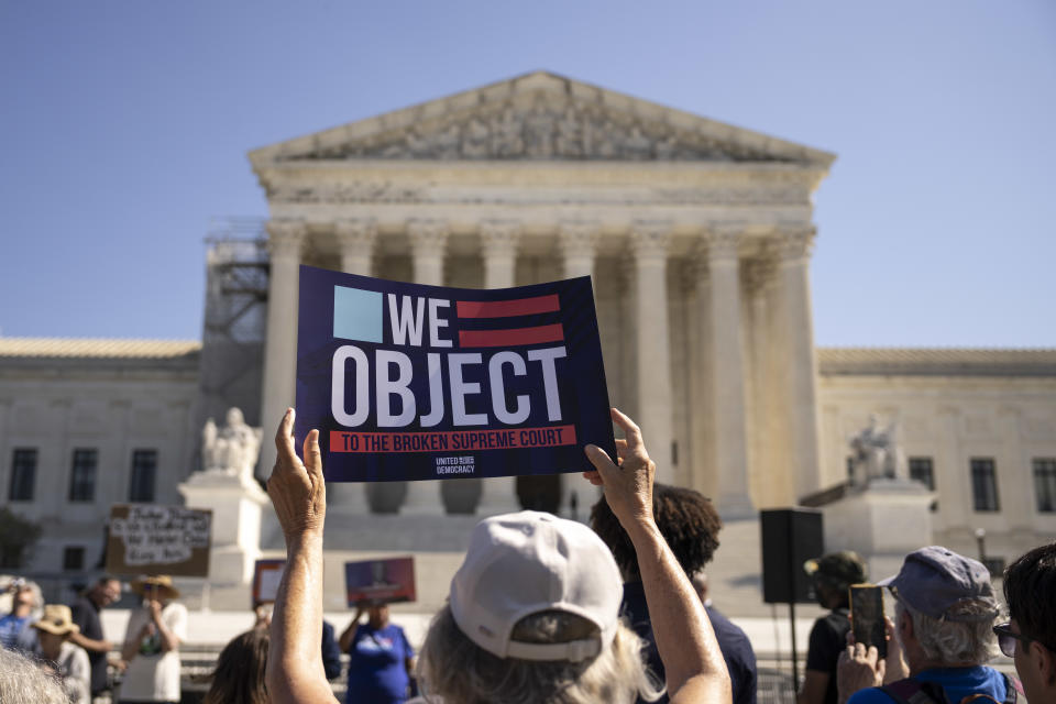 Demonstrators outside the Supreme Court on Monday. One holds a sign reading: We object to the broken Supreme Court.