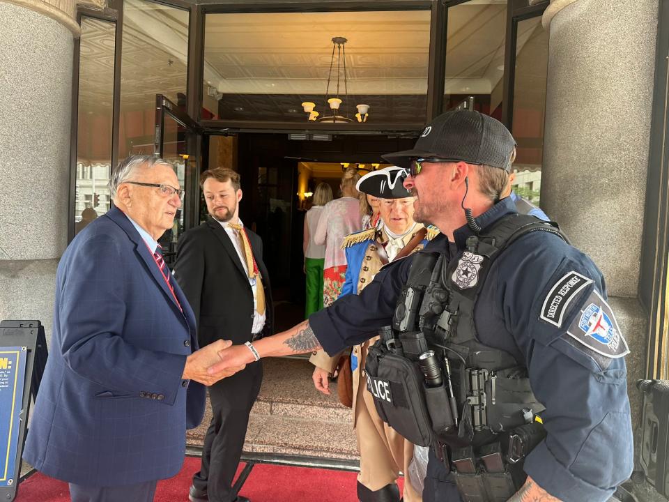 Joe Arpaio, a former sheriff of Maricopa County in Arizona, shakes hands with police outside the Pfister Hotel in downtown Milwaukee for an RNC event on Tuesday, July 16, 2024.