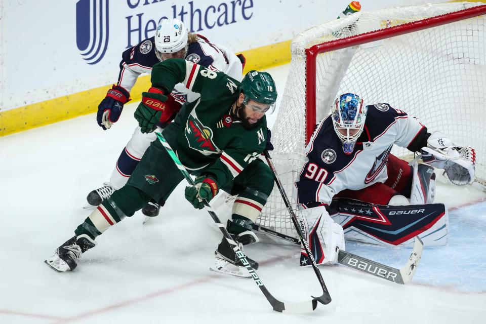 Mar 26, 2022; Saint Paul, Minnesota, USA; Minnesota Wild left wing Jordan Greenway (18) controls the puck against Columbus Blue Jackets goaltender Elvis Merzlikins (90) and left wing Patrik Laine (29) in the third period at Xcel Energy Center. Mandatory Credit: David Berding-USA TODAY Sports