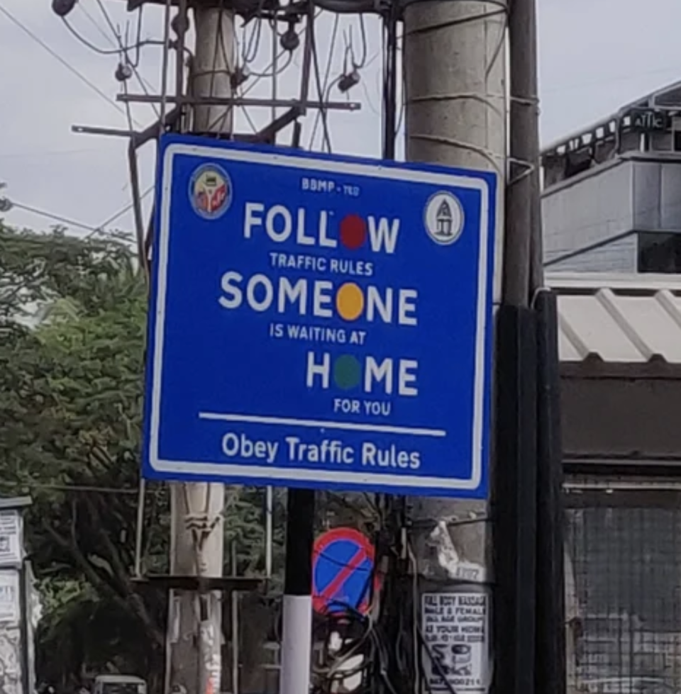 A sign that says "follow traffic rules, someone is waiting at home for you"