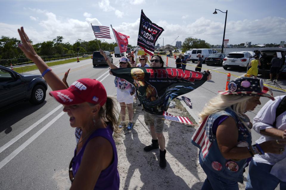 People wave to passing cars as they show support for former President Donald Trump one day after he was indicted by a Manhattan grand jury, Friday, March 31, 2023, outside Trump’s Mar-a-Lago estate in Palm Beach, Fla. 