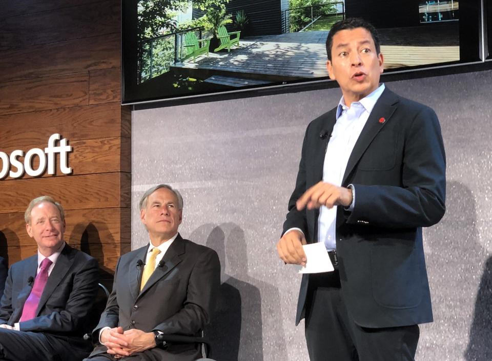 Ricardo Mora, CEO of Juarez Technology Hub, speaks at a Microsoft event in El Paso in 2019, as Texas Governor Greg Abbott, middle, and Microsoft President Brad Smith listen.