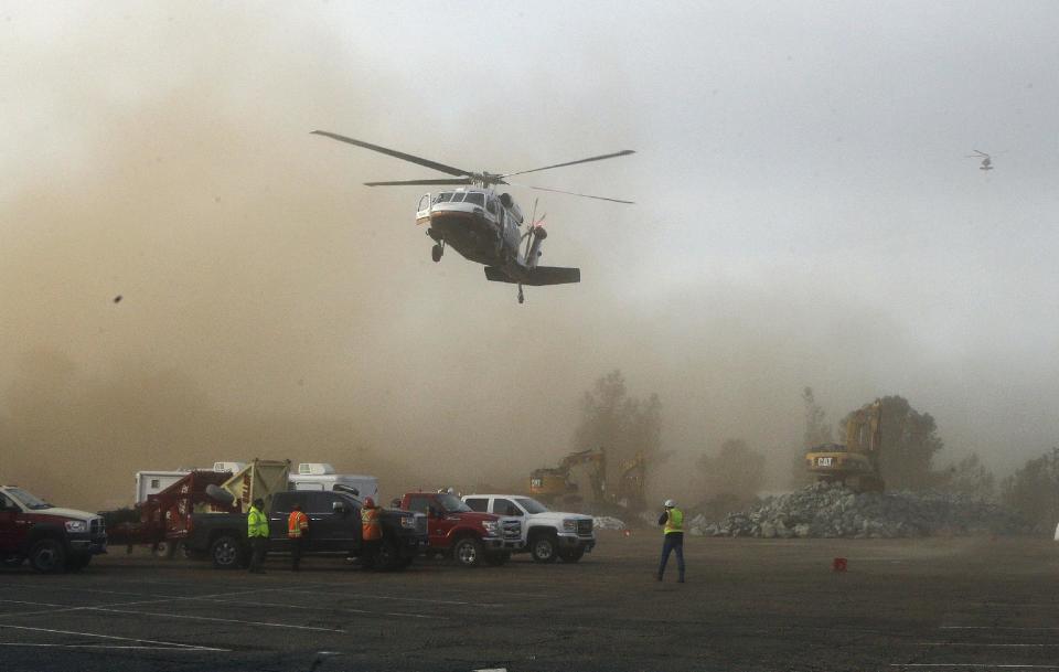 A helicopter kicks up dust as it lands at a staging area near the Oroville Dam on Monday, Feb. 13, 2017, in Oroville, Calif. State officials have discussed using helicopters to drop loads of rock on the damaged emergency spillway of the dam. (AP Photo/Rich Pedroncelli)