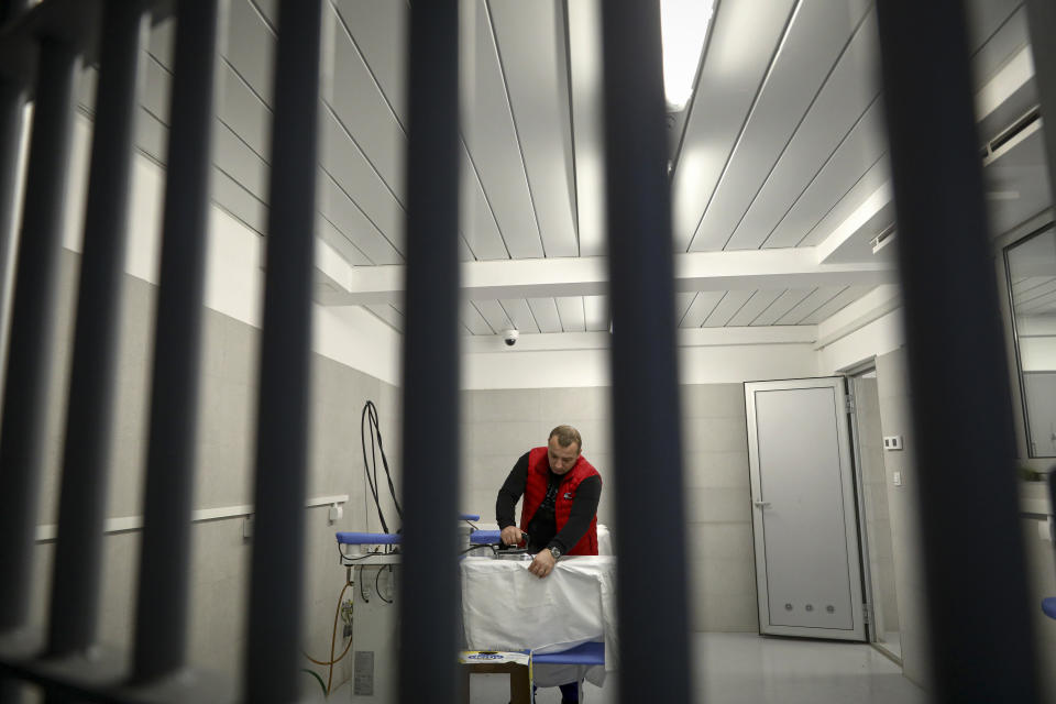 An inmate irons medical protection equipment in Zenica, Bosnia, on Nov. 23, 2021. In the early days of the pandemic and Bosnia was facing shortages of personal protective equipment, inmates in Zenica were offered to take up sewing protective face masks and other items as part of the prison's work program. (AP Photo)