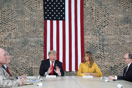 U.S. President Donald Trump, flanked by National Security Adviser John Bolton, first lady Melania Trump and U.S. Ambassador to Iraq Doug Silliman, meets political and military leaders during an unannounced visit to Al Asad Air Base, Iraq December 26, 2018. REUTERS/Jonathan Ernst