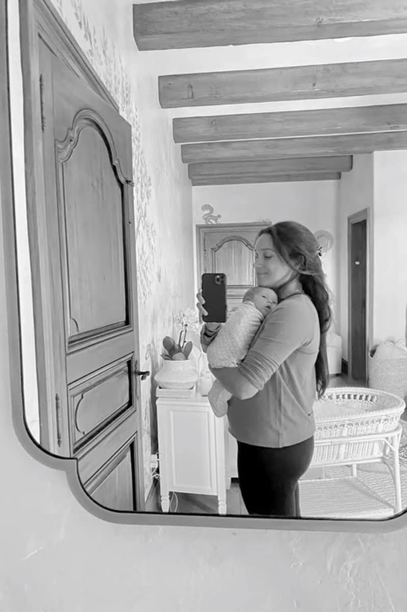 <p>Mom cradles her little girl in a sweet mirror selfie.</p>