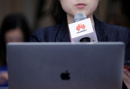 A journalist holding a microphone with a Huawei logo asks questions next to her MacBook Air at a news conference on Huawei’s ongoing legal action against the U.S. government’s National Defense Authorization Act (NDAA) action at its headquarters in Shenzhen, Guangdong province, China May 29, 2019. REUTERS/Jason Lee