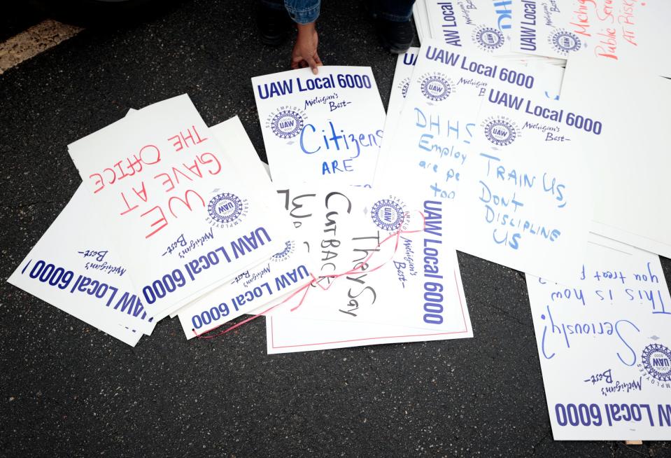 A Michigan Department of Health & Human Services worker picks up a picket sign and heads to join over forty others in from of the DHHS office on Conner Avenue in Detroit on Wednesday, September 27, 2023. They were participating in an Informational Picket to bring more attention to their caseloads that are out of control and workers being overworked.