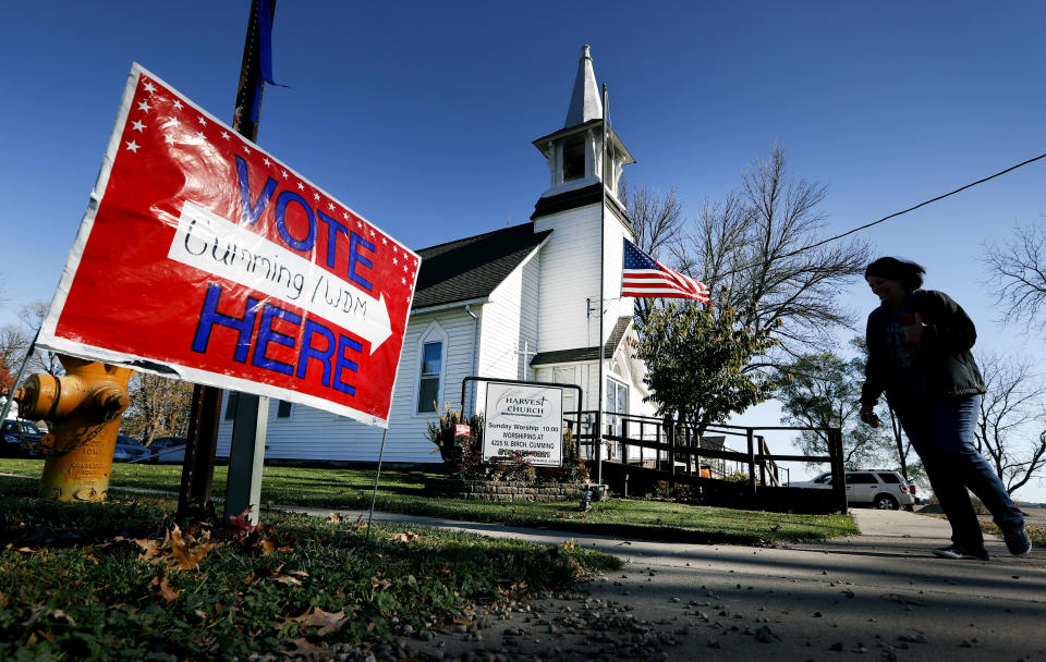 FILE - In this Tuesday, Nov. 8, 2016 file photo, a local resident leaves a church after voting in the general election in Cumming, Iowa. Religion's role in politics and social policies is in the spotlight heading toward the midterm elections, yet relatively few Americans consider it crucial that a candidate be devoutly religious or share their religious beliefs, according to an AP-NORC national poll conducted Aug. 16-20, 2018. (AP Photo/Charlie Neibergall)