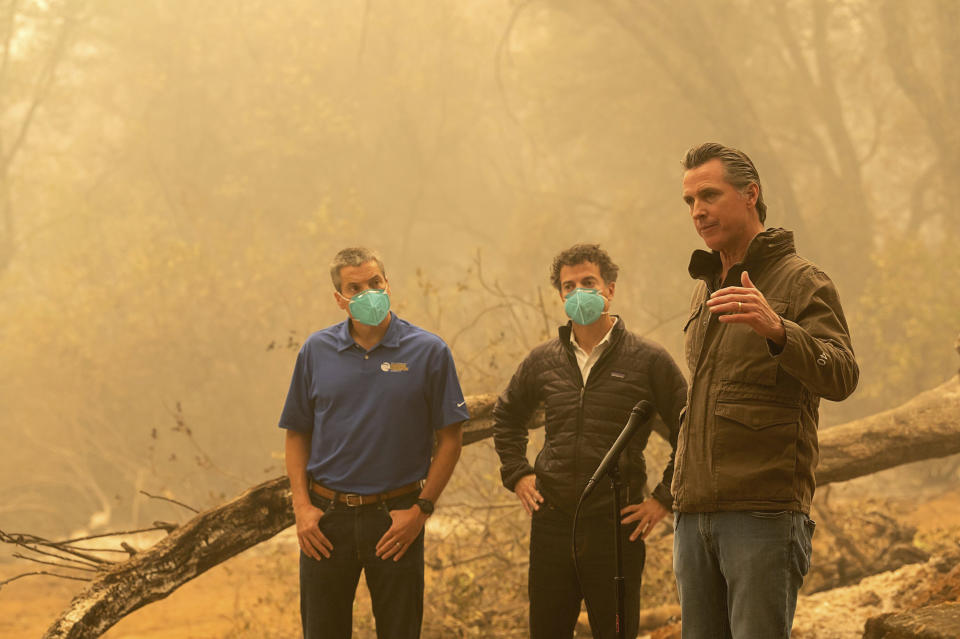 California Gov. Gavin Newsom, right, speaks to the media after he toured the North Complex Fire zone with California Secretary for Natural Resources Wade Crowfoot, left, and California Secretary for Environmental Protection Jared Blumenfeld in Butte County on Friday, Sept. 11, 2020, outside of Oroville, Calif. Gov. Gavin Newsom toured the fire-ravaged region Friday and strongly asserted that climate change was evident and pledged to redouble efforts to “decarbonize” the economy. (Paul Kitagaki Jr./The Sacramento Bee via AP, Pool)