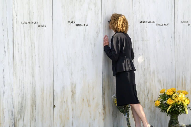 Deb Borza, daughter of Flight 93 victim Deora Frances Bodley, pauses and kisses the name of her mother before the public wreath laying service at the Flight 93 National Memorial on Monday near Shanksville, Penn. Photo by Archie Carpenter/UPI