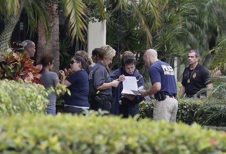 Federal and state law enforcement officials gather outside the office of Med-Care Diabetic and Medical Supplies company during a raid in Boca Raton, Florida, January 14, 2015. REUTERS/Andrew Innerarity