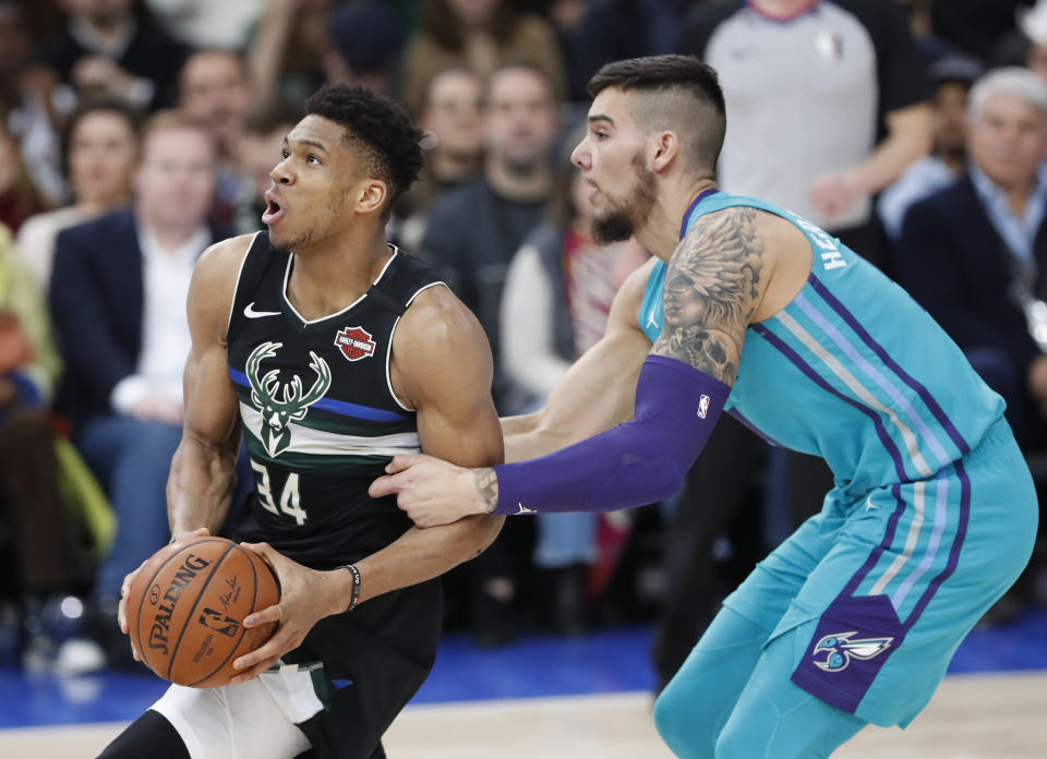 Charlotte Hornets center Willy Hernangomez (9) holds Milwaukee Bucks forward Giannis Antetokounmpo (34) during NBA game in Paris, Friday, Jan. 24, 2020. (AP Photo/Thibault Camus))