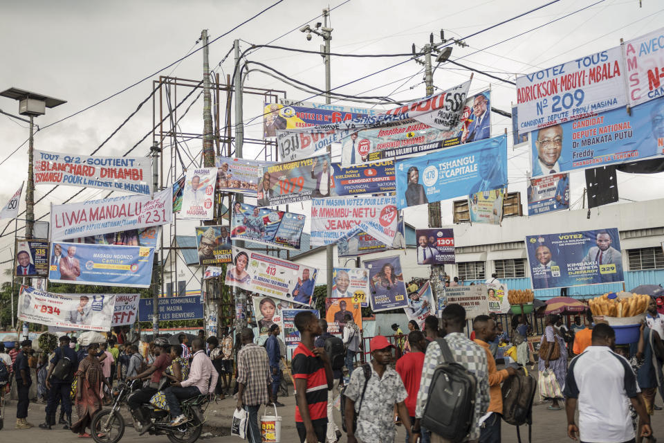 People walk in front of election banners in Kinshasa, Democratic Republic of the Congo, Saturday, Dec. 9, 2023. President and second-term candidate Felix Tshisekedi has declared that people living in the eastern territories of Masisi and Rutshuru will not be taking part in the elections, a move local activists and observers say could affect the credibility of the vote. (AP Photo/Samy Ntumba Shambuyi)