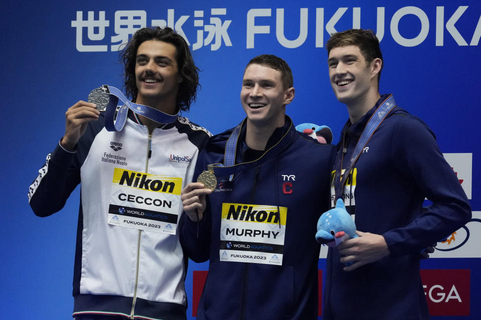 Gold medalist Ryan Murphy, center, of the United States, silver medalist Thomas Ceccon, left, of Italy and bronze medalist Hunter Armstrong of the United States pose during ceremonies of the Men's 100m backstroke finals at the World Swimming Championships in Fukuoka, Japan, Tuesday, July 25, 2023. (AP Photo/Lee Jin-man)