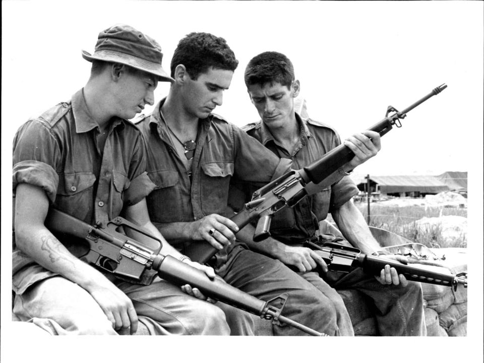 Soldiers looking at an M-15 rifle in 1965.