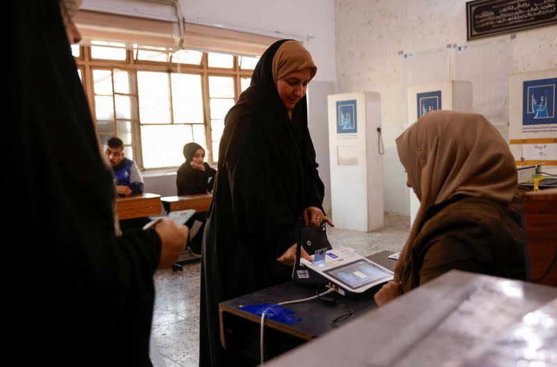 An Iraqi woman has her fingerprints scanned to verify her identity before voting at a polling station, during Iraq's provincial council elections, in Baghdad