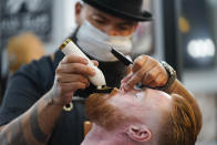 Braunson McDonald has his beard trimmed by Luis Lopez, owner of Orange County Barbers Parlor, on Wednesday, July 15, 2020, in Huntington Beach, Calif. Gov. Gavin Newsom this week ordered that indoor businesses like salons, barber shops, restaurants, movie theaters, museums and others close due to the spread of COVID-19. (AP Photo/Ashley Landis)