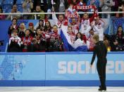 Evgeny Plyushchenko of Russia looks at his Russian teammates as the Canadian team looks on, during the Team Men Short Program at the Sochi 2014 Winter Olympics, February 6, 2014. REUTERS/Alexander Demianchuk (RUSSIA - Tags: SPORT FIGURE SKATING OLYMPICS)