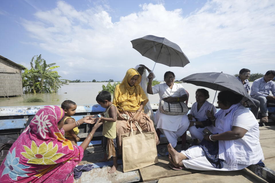 25-year-old Jahanara Khatoon, who is at full-term pregnancy, travels on a boat on her way to a health centre, in Sandoh Khaiti Char, in the northeastern Indian state of Assam, Wednesday, July 3, 2024. (AP Photo/Anupam Nath)