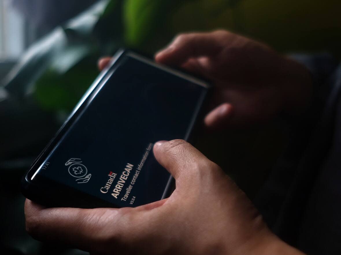 A person holds a smartphone set to the opening screen of the ArriveCan app. (Giordano Ciampini/Canadian Press - image credit)