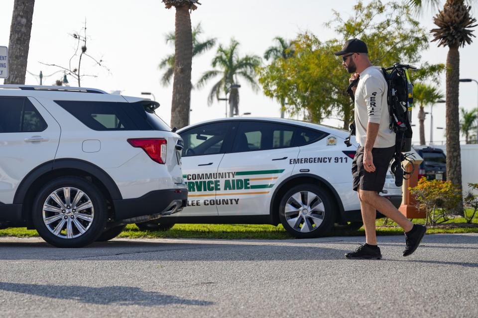 A sheriff’s deputy carries scuba gear to search for a missing Florida Gulf Coast University student at a lake shared with FGCU and the Miromar Lakes community in Fort Myers on Thursday, Aug. 24, 2023.