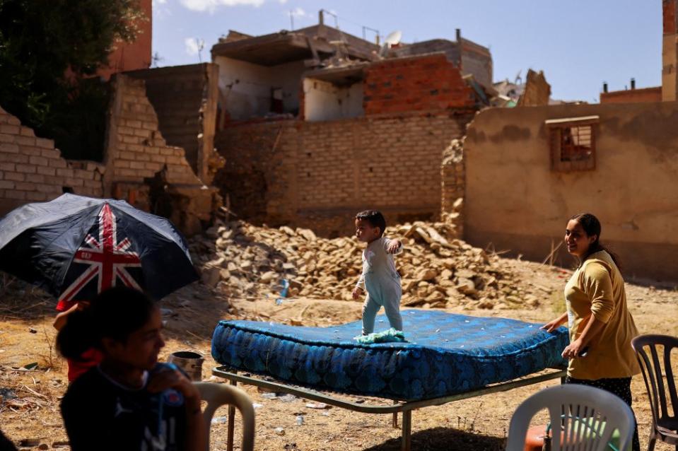 Hiba, 21, looks on as her two-year-old daughter Sei Eddine plays on the mattress in the aftermath of a deadly earthquake in Amizmiz on Sept. 10. <span class="copyright">Nacho Doce—Reuters</span>