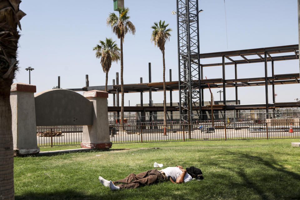 A man lies on the grass as the temperature reaches 115 degrees on June 12, 2022, in Calexico, Calif. (Sandy Huffaker / Getty Images file)