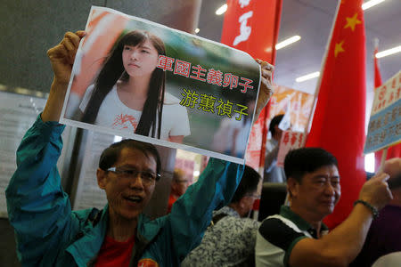 A protester carries a printout depicting legislator-elect Yau Wai-ching as a traitor during a demonstration outside the Legislative Council in Hong Kong, China October 19, 2016. REUTERS/Bobby Yip