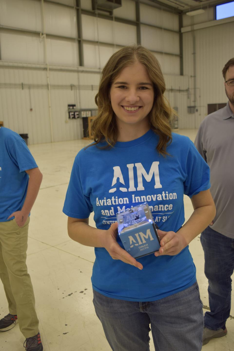 Dinah Roth holds a lamp that she made as part of the Aviation Innovation and Maintenance (A.I.M.) Center of Excellence program at Salina Regional Airport. Roth was one of the first nine students to graduate from the six-week program.