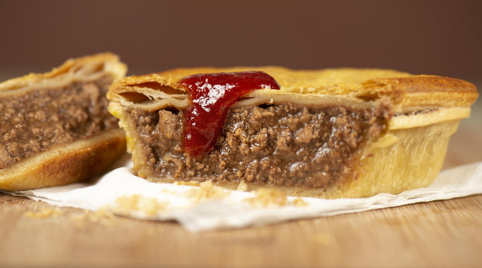 An Australian meat pie with tomato ketchup.