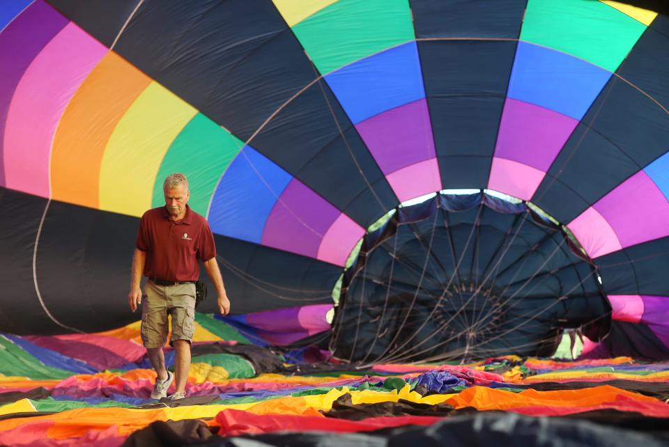 Pilot Denny Wesler checks the inside lines as the balloon is inflated as he gets ready to take passengers for a ride on the hot air balloon on Friday in Portage County.