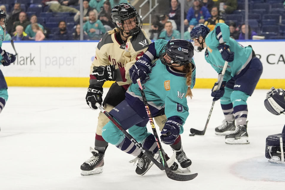 Montreal's Tereza Vanisova (21) knocks down New York's Brooke Hobson (6) during the second period of a PWHL hockey game Wednesday, March 6, 2024, in Bridgeport, Conn. (AP Photo/Frank Franklin II)