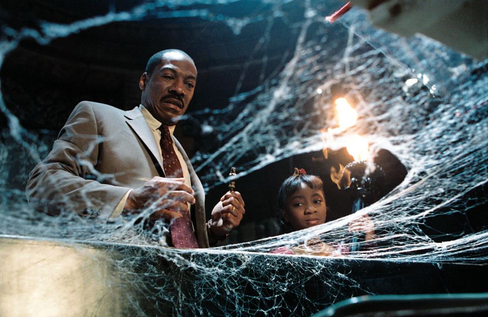 Eddie Murphy and Aree Davis look through cobwebs