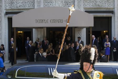 A member of a bagpipe ensemble gestures as mourners depart the funeral of comedian Joan Rivers at Temple Emanu-El in New York September 7, 2014. REUTERS/Lucas Jackson