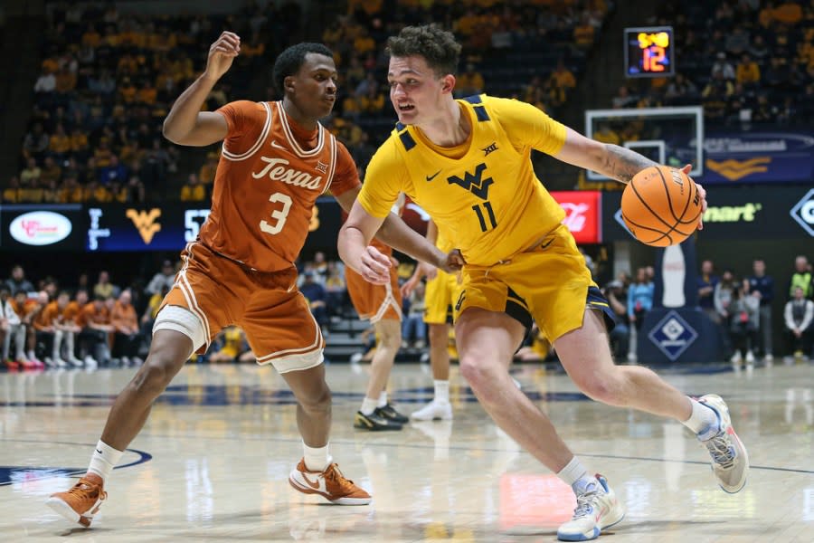 West Virginia forward Quinn Slazinski (11) is defended by Texas guard Max Abmas (3) during the second half of an NCAA college basketball game on Saturday, Jan. 13, 2024, in Morgantown, W.Va. (AP Photo/Kathleen Batten)