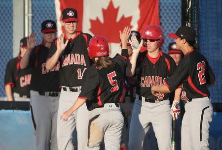 Jul 20, 2015; Toronto, Ontario, CAN; Canada second baseman Nicole Luchanski (5) is congratulated by teammates after scoring the first run of the game in the third inning against Cuba during a women's baseball game in the 2015 Pan Am Games at Ajax Pan Am Ballpark. Mandatory Credit: Tom Szczerbowski-USA TODAY Sports